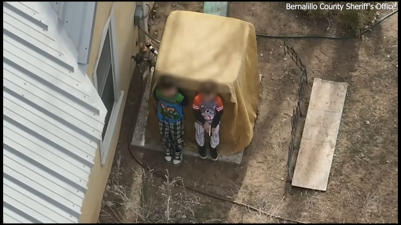Two boys, ages 7 and 9, can be seen holding a loaded firearm in a standoff