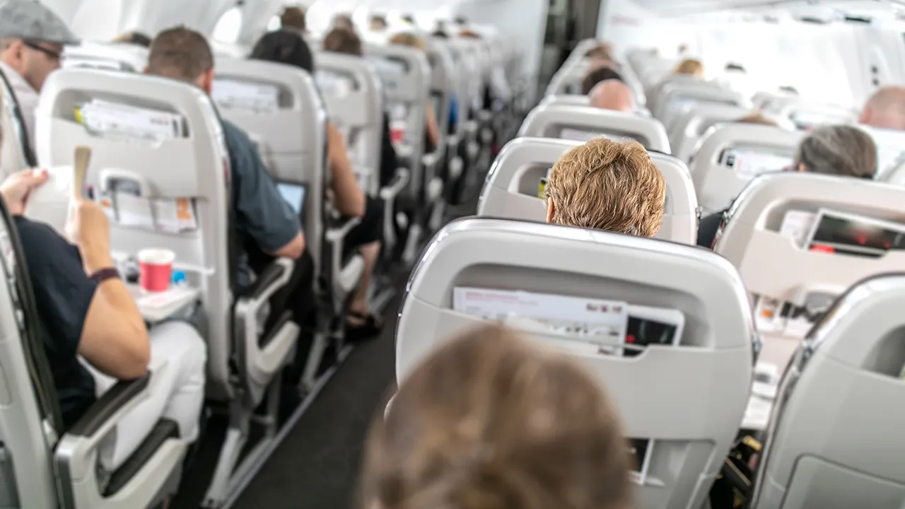 Flight passenger hides suitcase behind curtain as attendants miss the violation